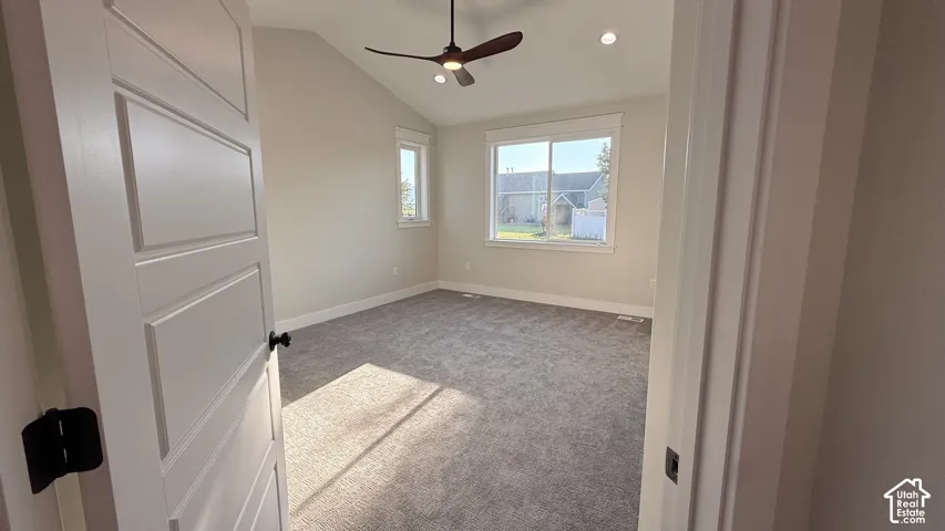 Vaulted ceiling, ceiling fan, recessed lighting, carpet flooring, and white trim