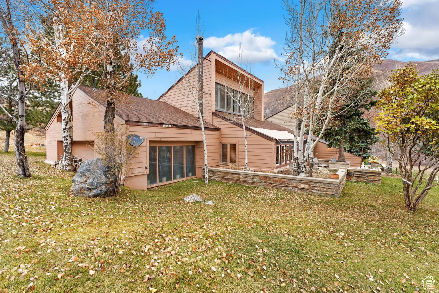 Back of house featuring a shingled roof and a yard