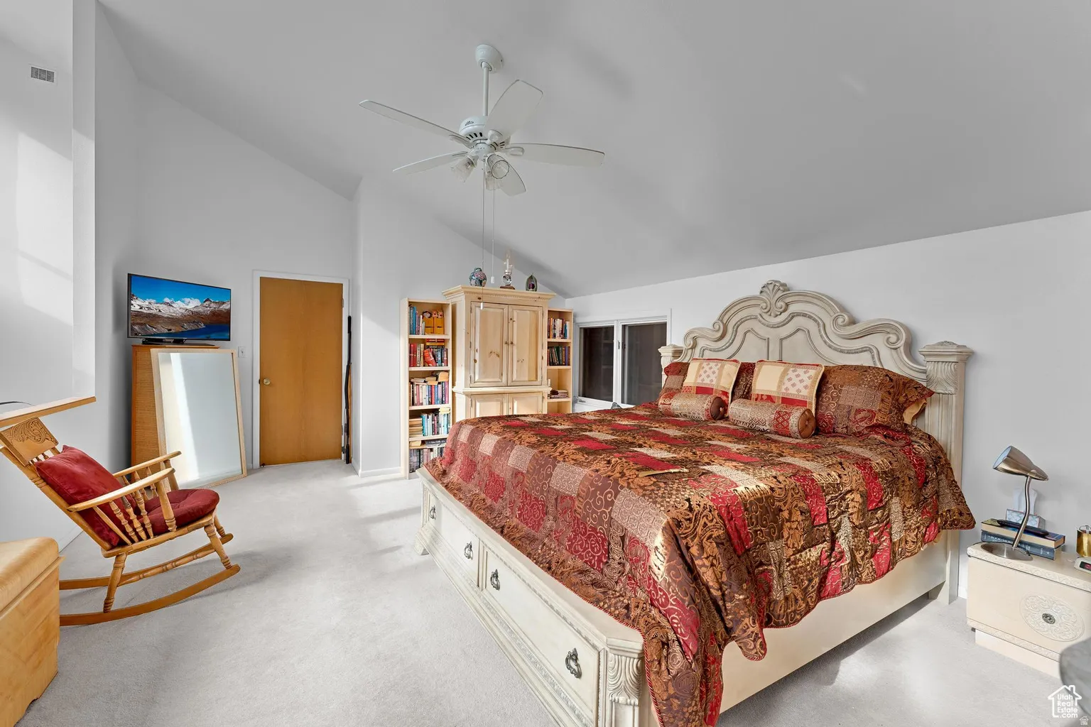 Primary Bedroom with lofted ceiling, ceiling fan, and light colored carpet
