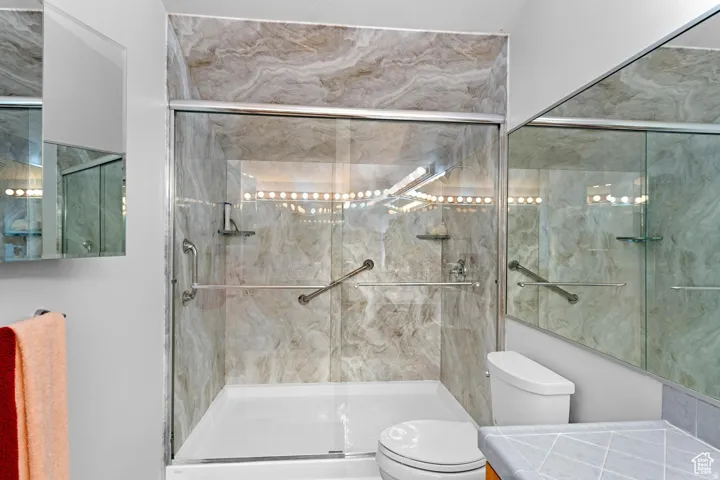 Primary Bathroom featuring a marble finish shower and vanity