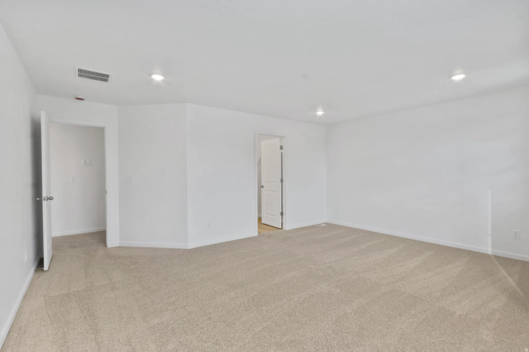 Unfurnished room with light carpet and recessed lighting