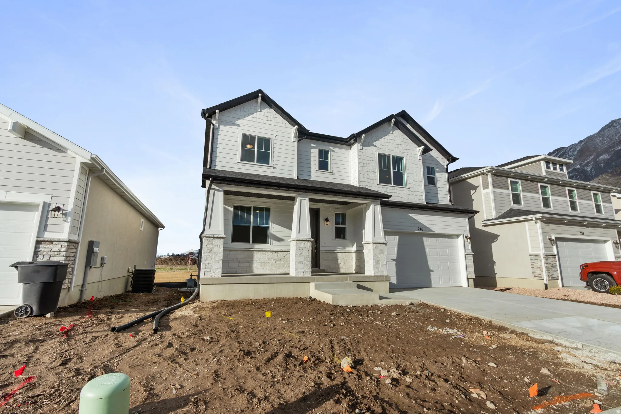 Craftsman-style home featuring a porch, a garage, and concrete driveway