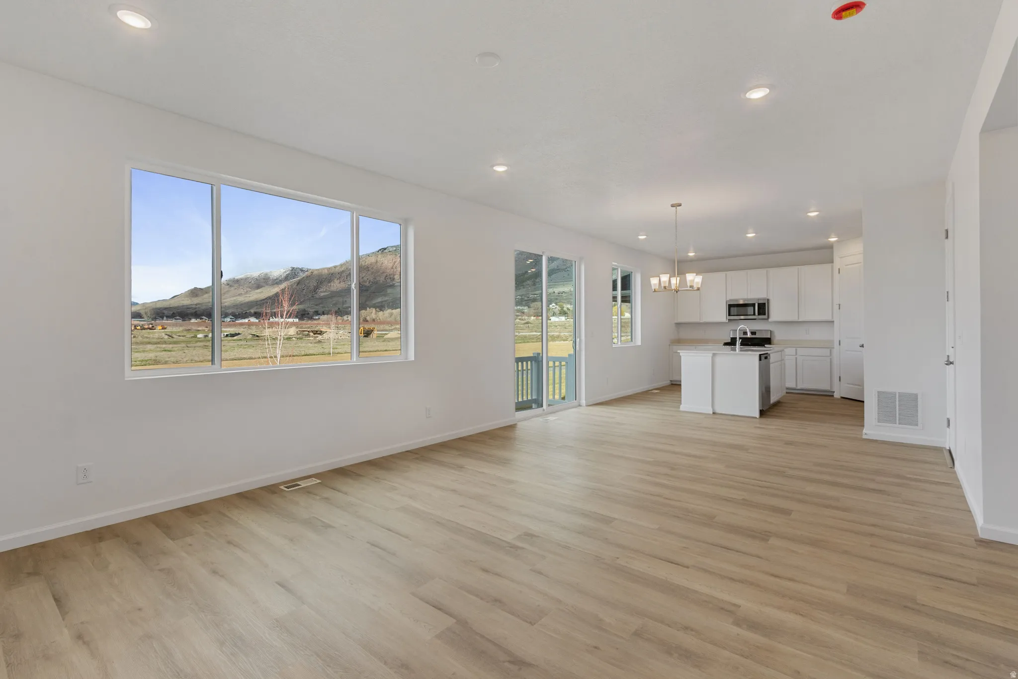 Unfurnished living room featuring a mountain view, a chandelier, and light wood finished floors