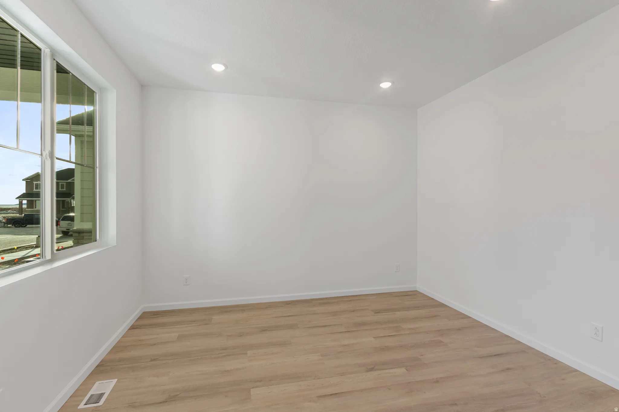 Empty room featuring light wood-style floors and recessed lighting