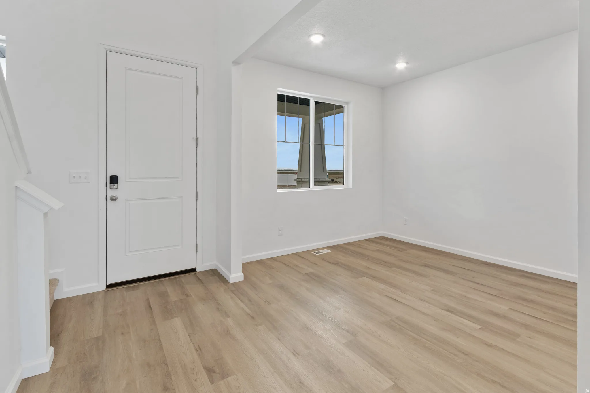 Foyer featuring light wood finished floors and recessed lighting