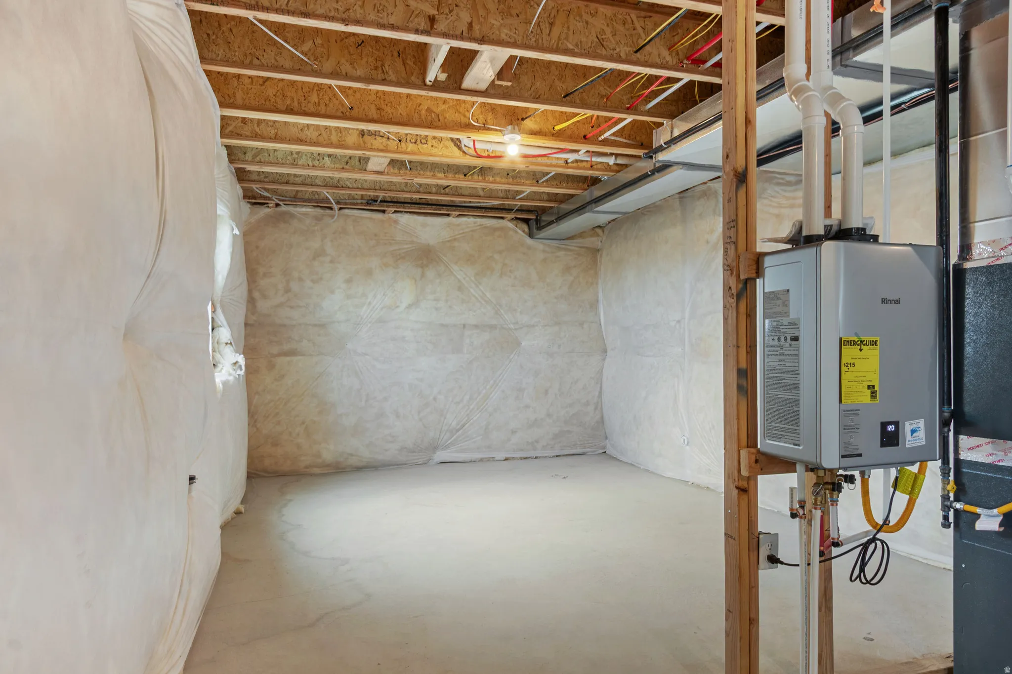 Unfinished below grade area featuring water heater