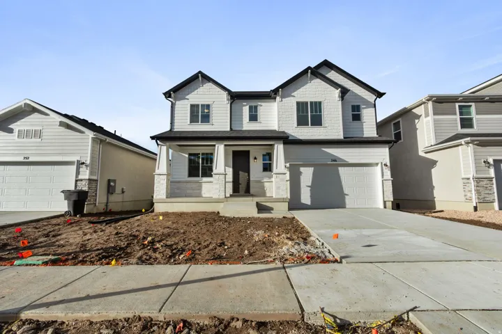 Craftsman-style home featuring covered porch, concrete driveway, a garage, and stone siding