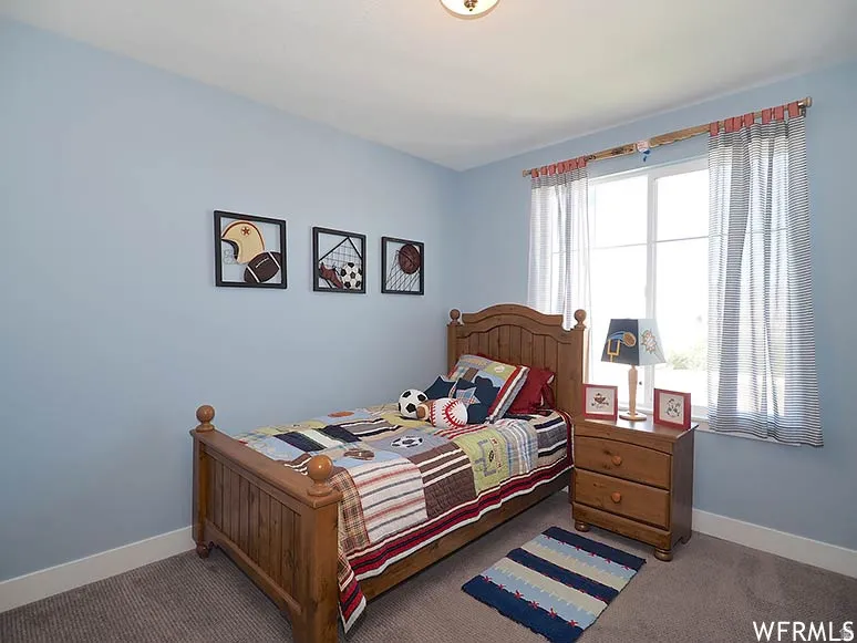Bedroom with dark carpet and baseboards