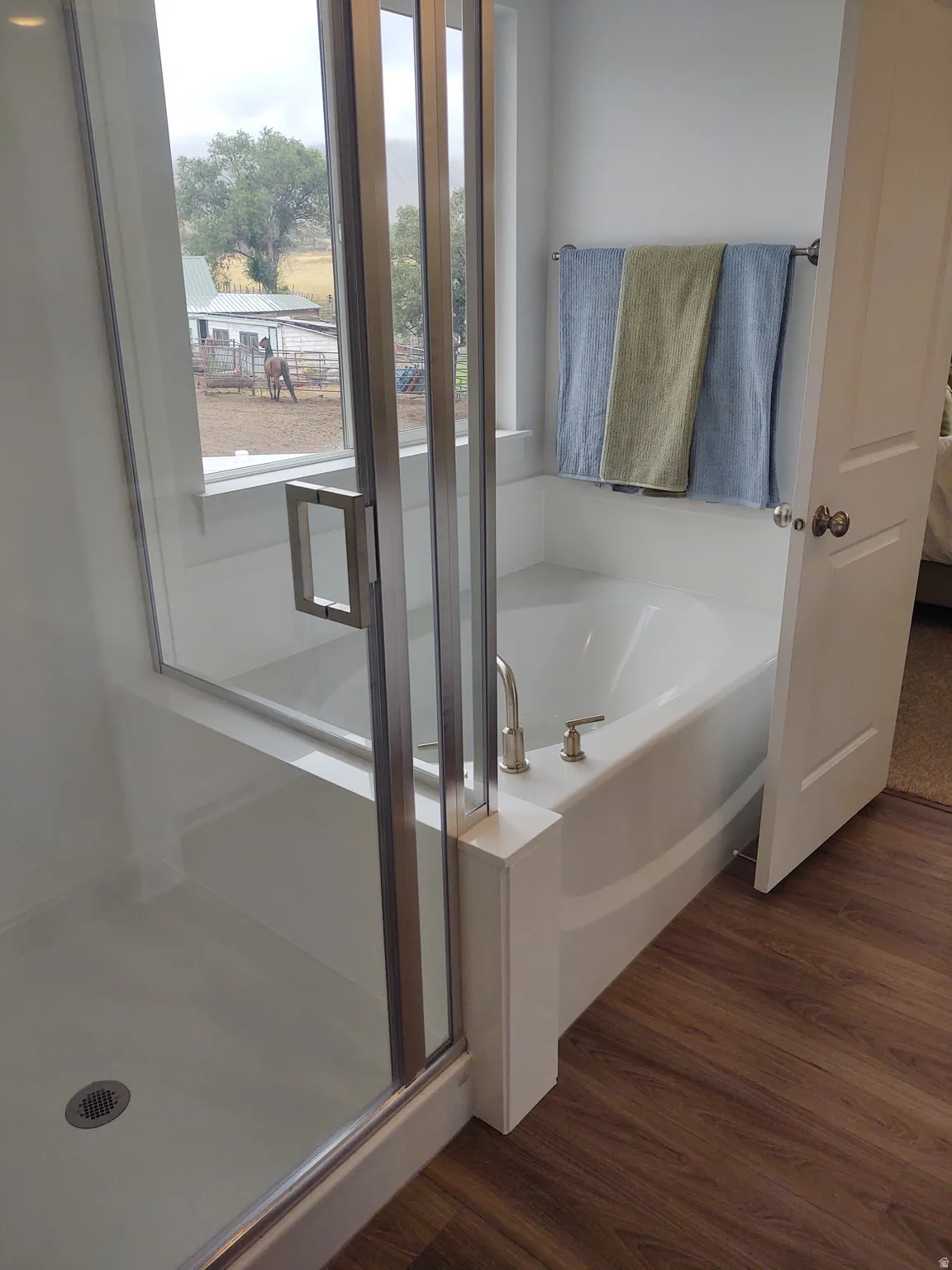 Bathroom with dark wood-style flooring, a bath, a stall shower, and connected bathroom