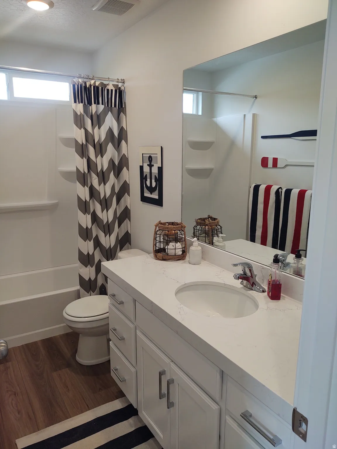 Bathroom featuring vanity, dark wood-type flooring, and shower / bath combination with curtain