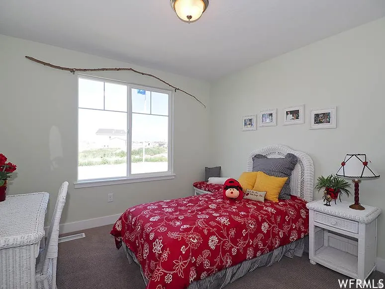 Bedroom featuring dark colored carpet and baseboards