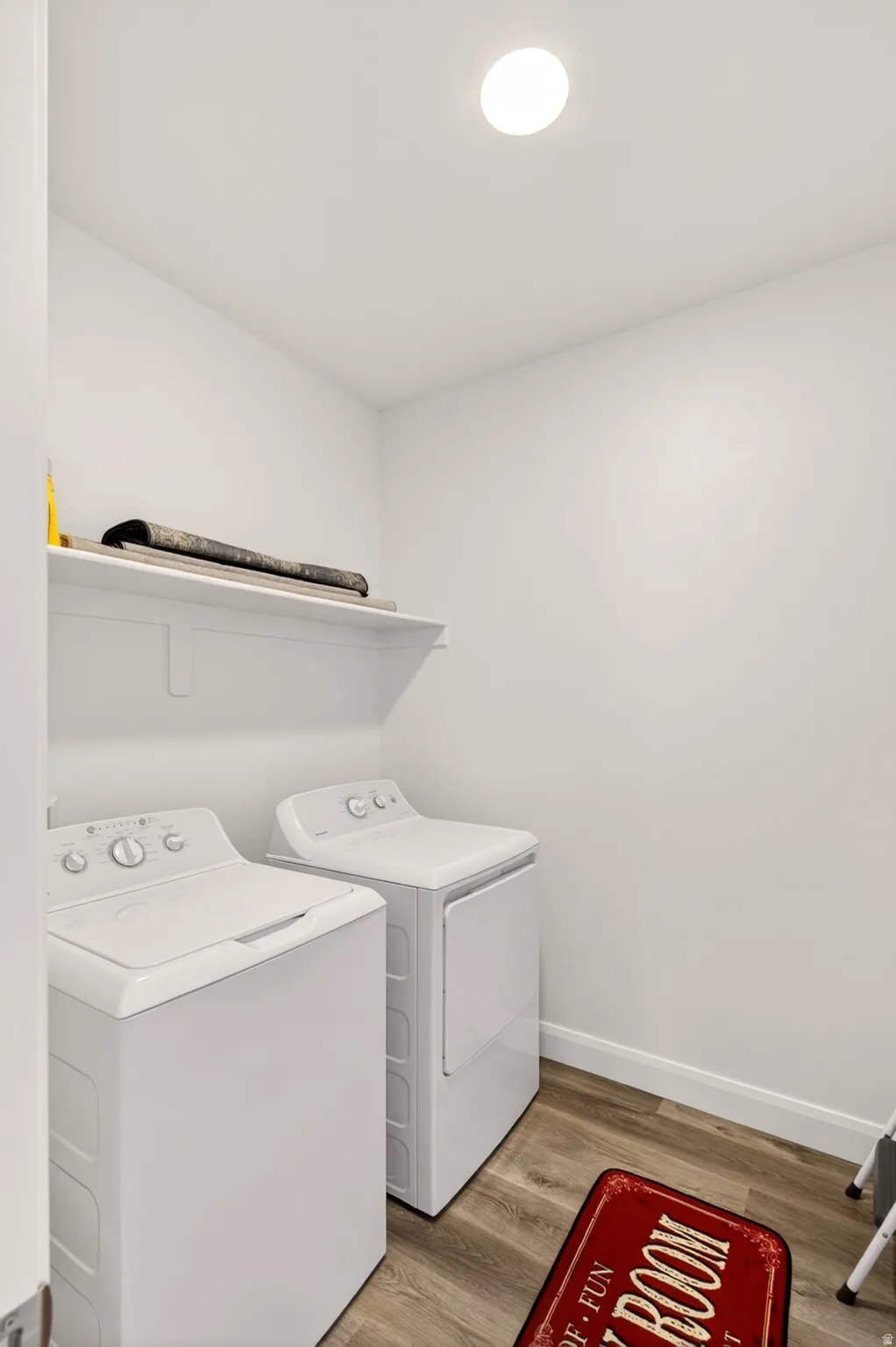 Laundry area with light wood-style floors and washer and dryer