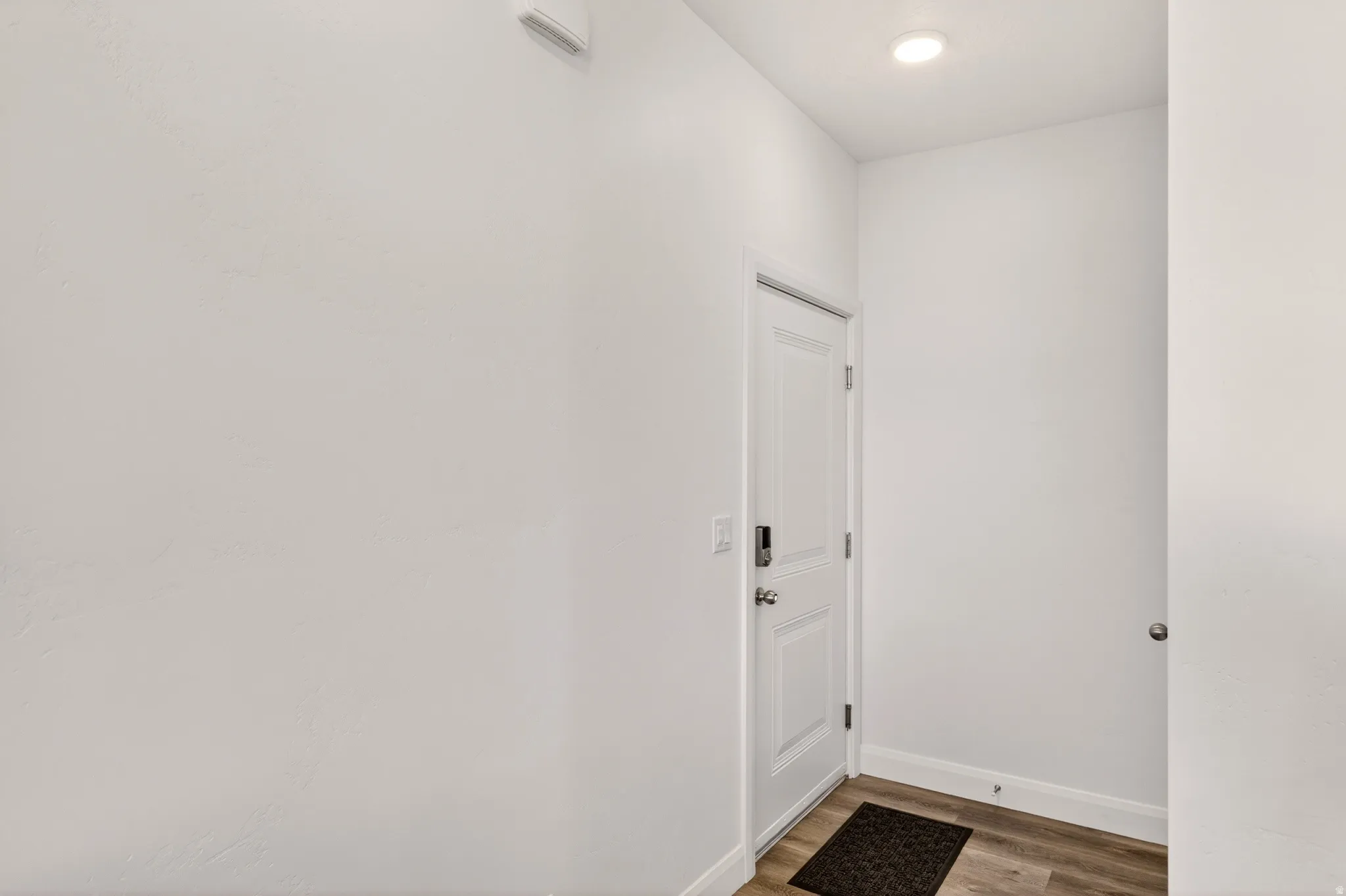 Doorway to outside featuring wood finished floors and baseboards