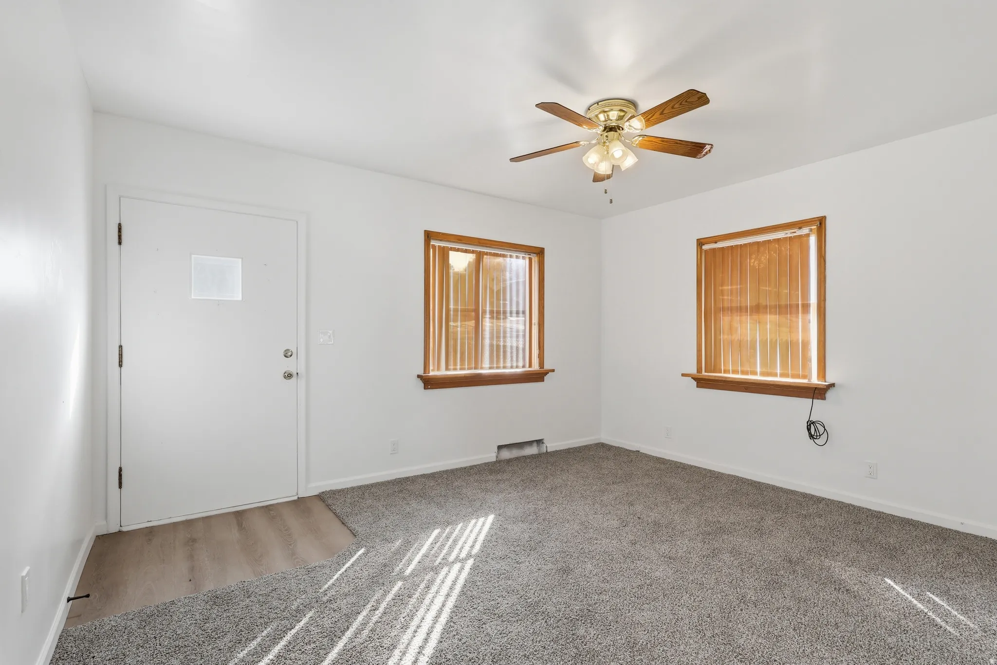 Entrance foyer featuring a ceiling fan and carpet