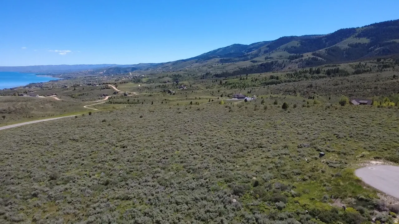 Expansive undeveloped land featuring natural vegetation and distant mountain ranges