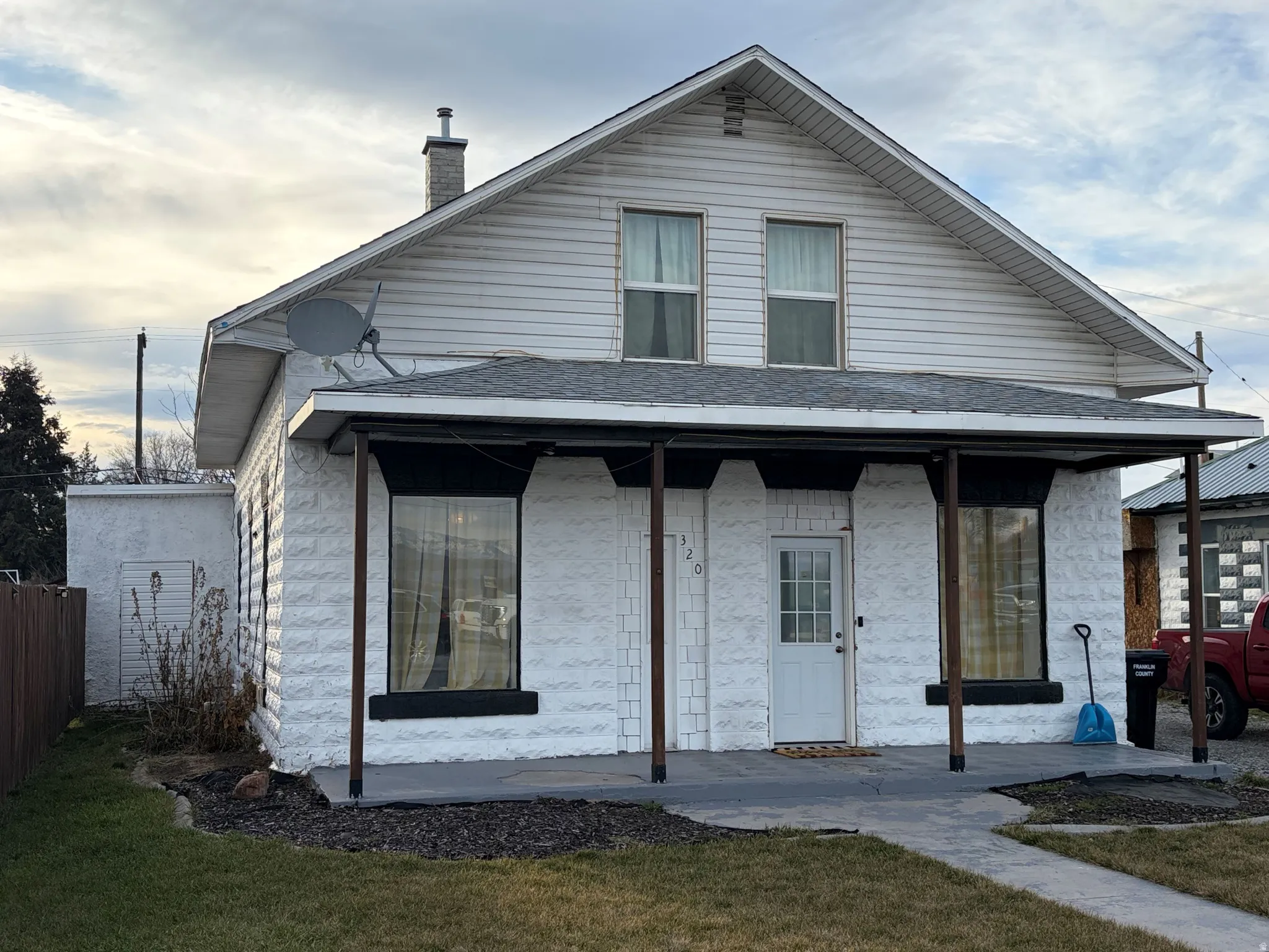 View of front facade with a porch and a chimney