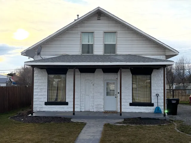 View of front of house with covered porch and a shingled roof