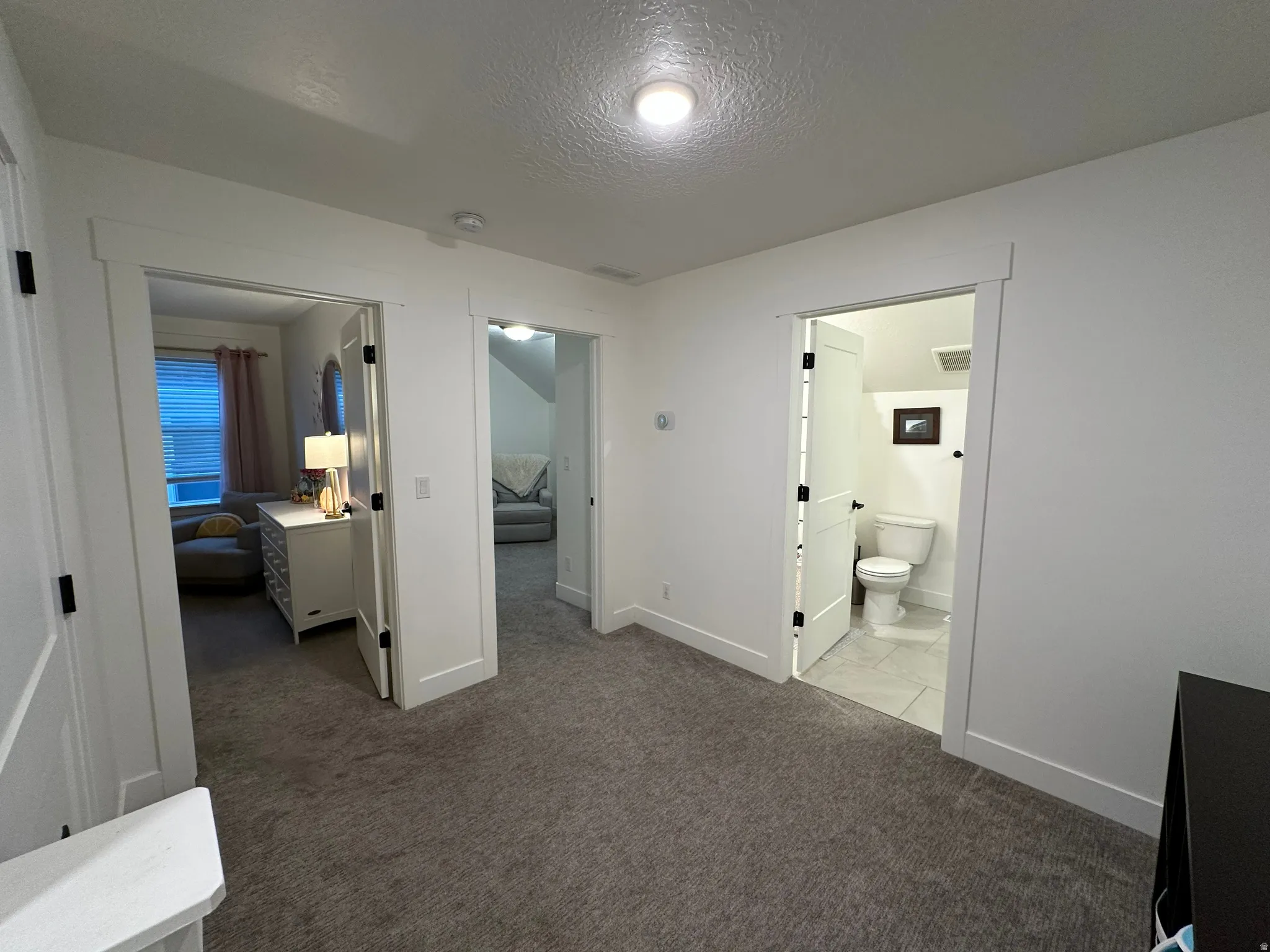 Third floor Hall featuring a textured ceiling and light carpet