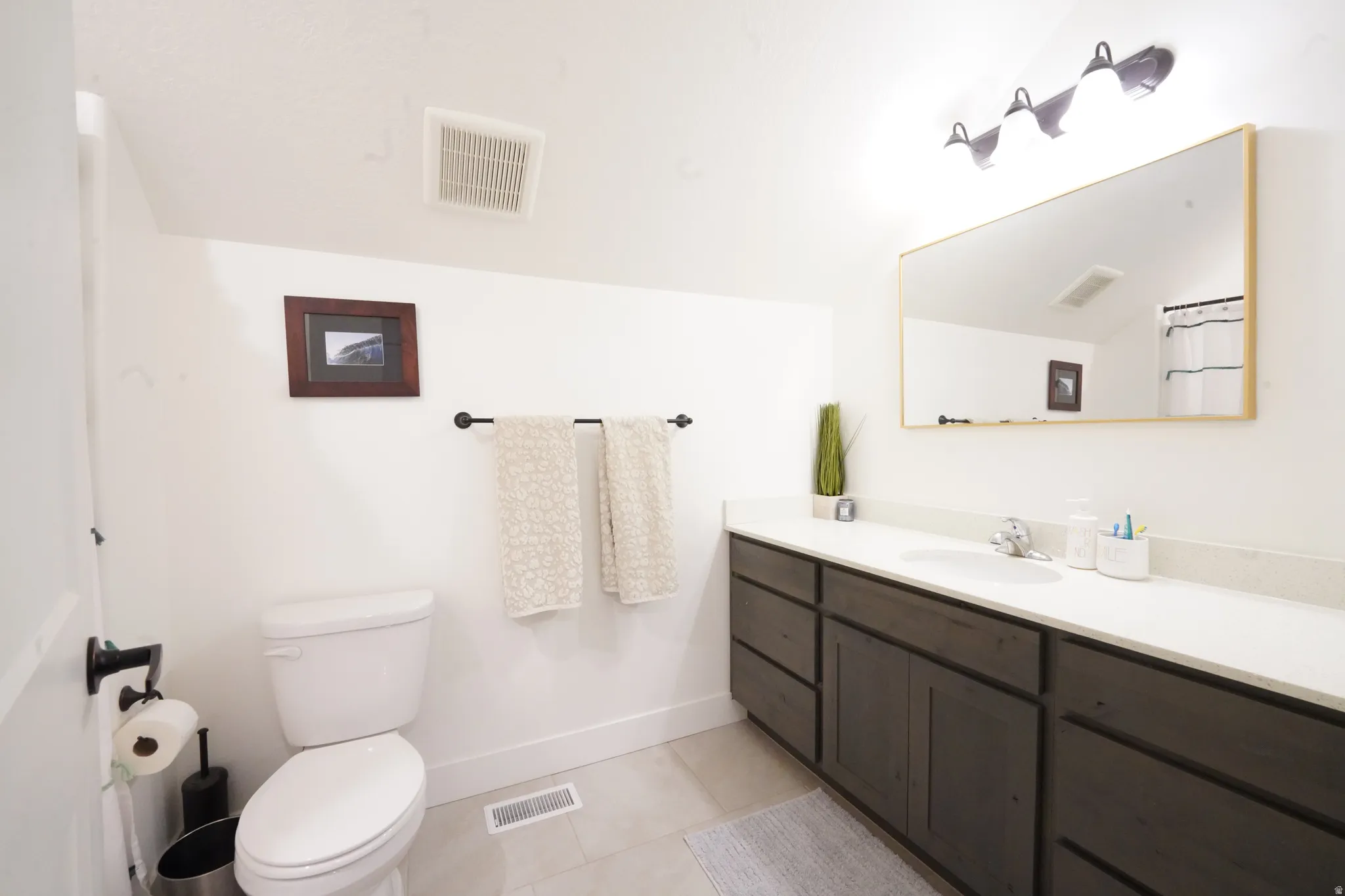 Bathroom with vanity, light tile patterned flooring, and a shower with curtain