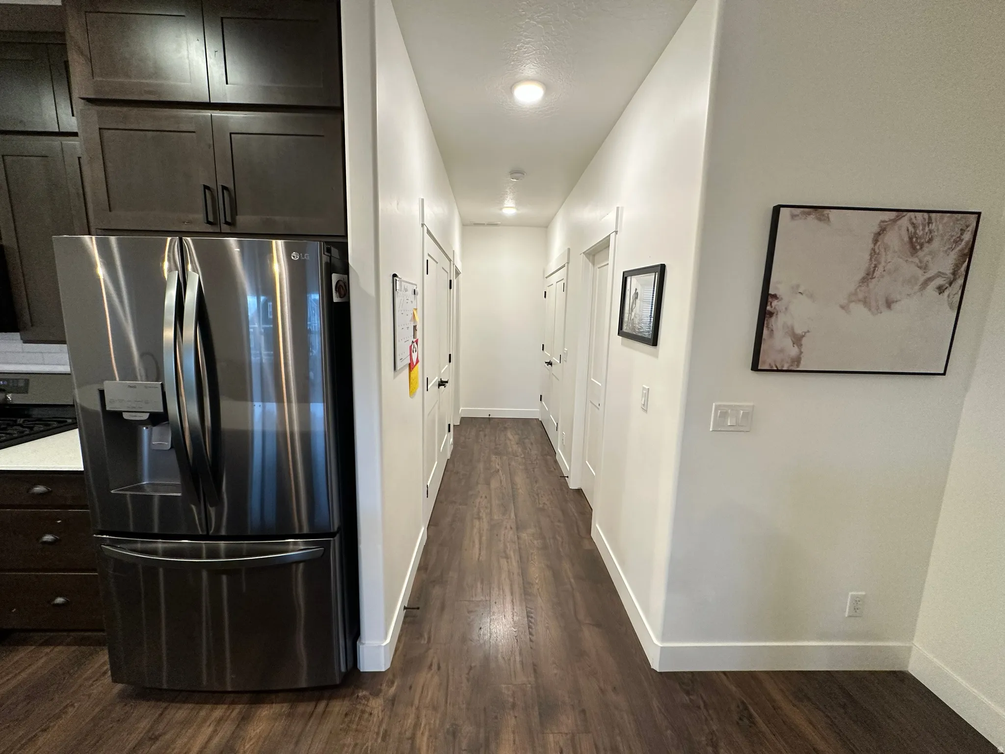 Hallway to Master ensuite featuring baseboards and dark wood-style floors