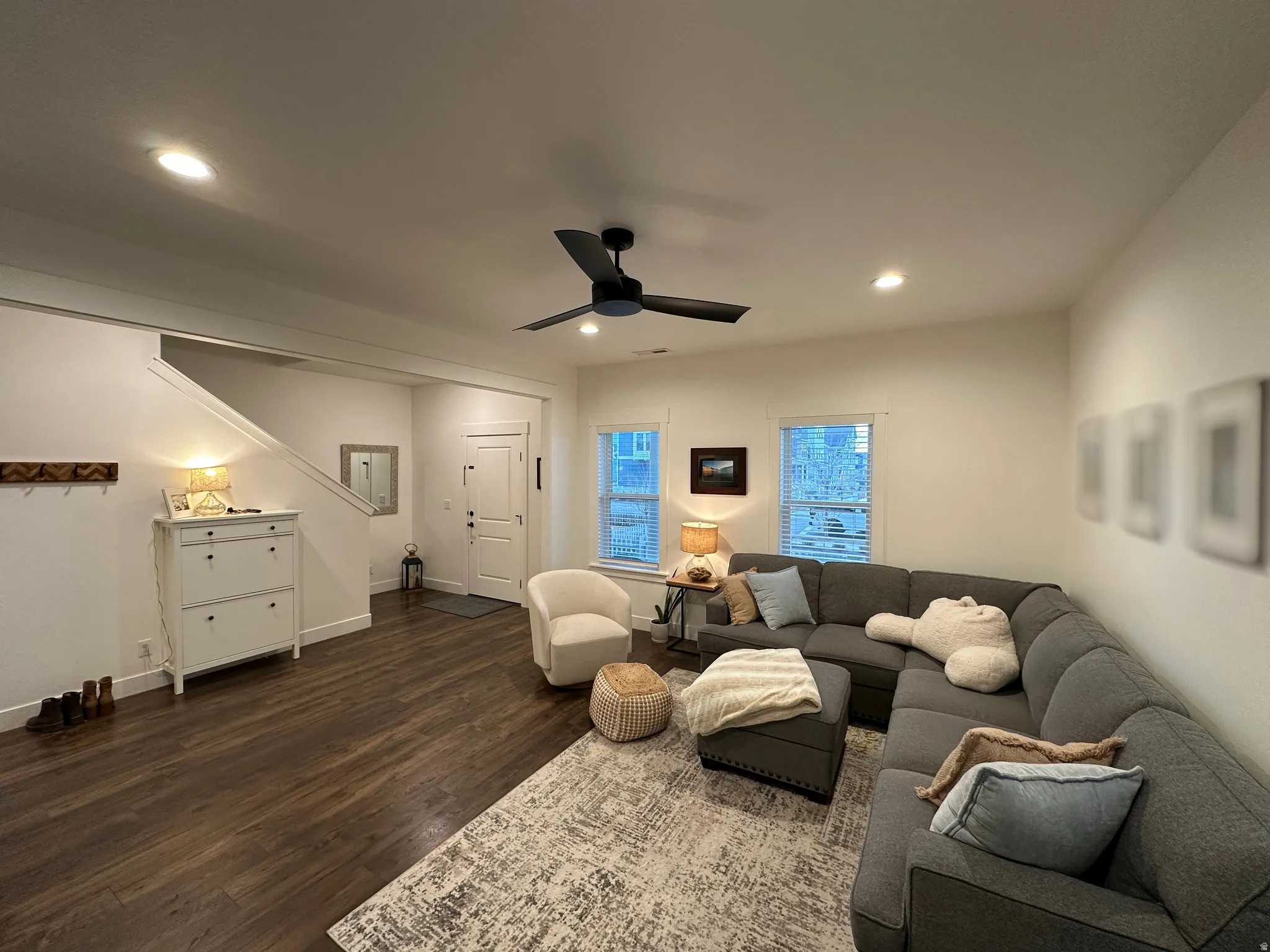 Living area with a ceiling fan, dark wood-style floors, and recessed lighting