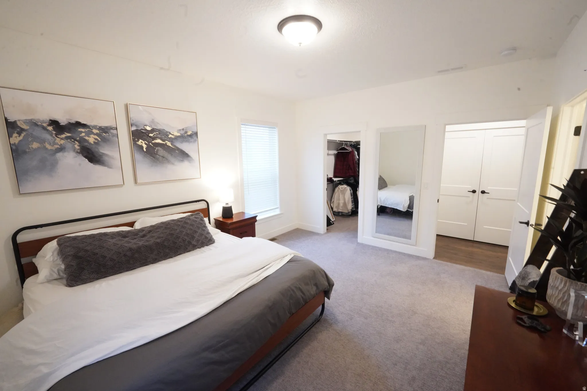 Bedroom featuring a walk in closet and light colored carpet