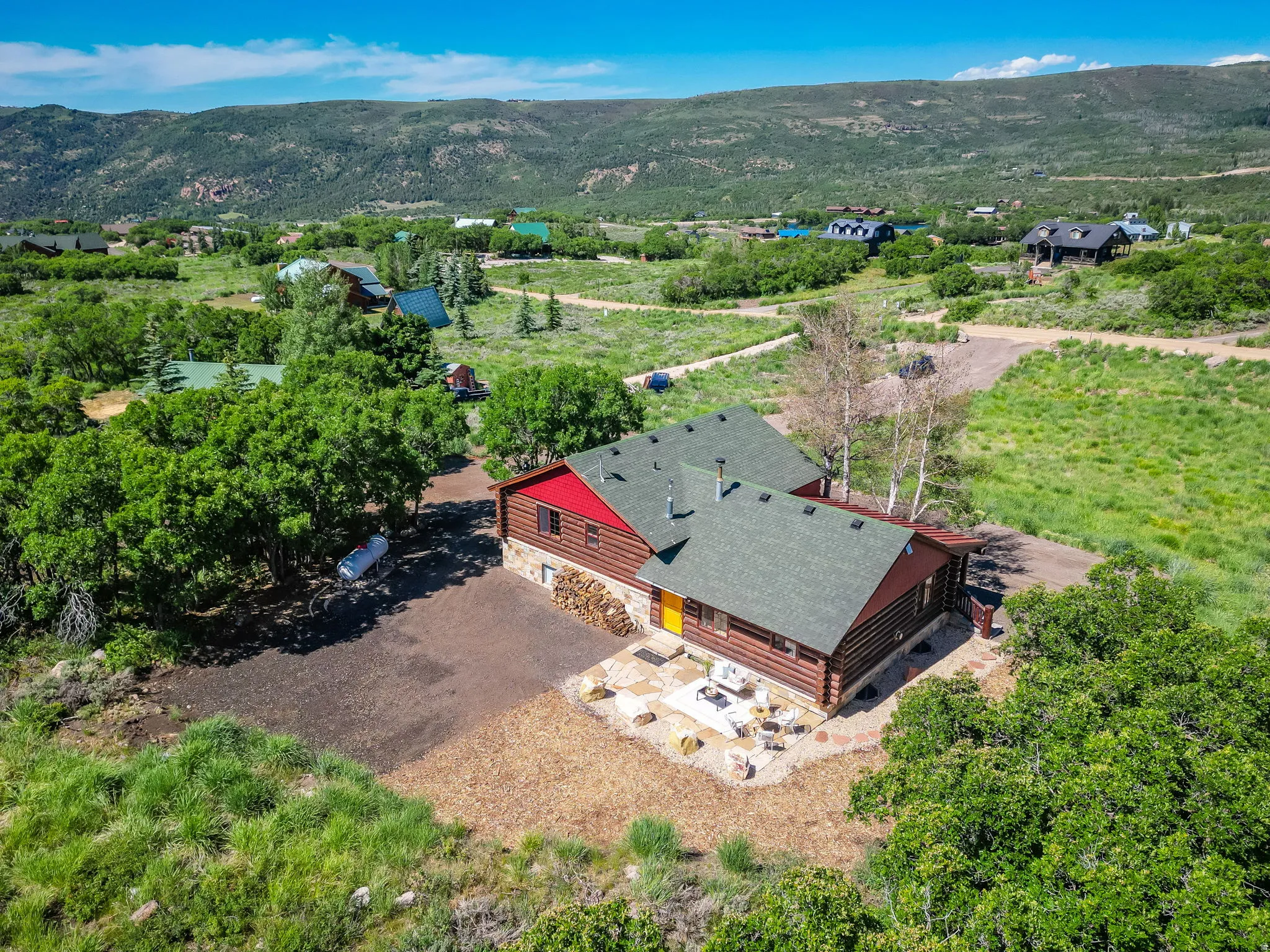 Log cabin exterior with a green roof and red siding accents