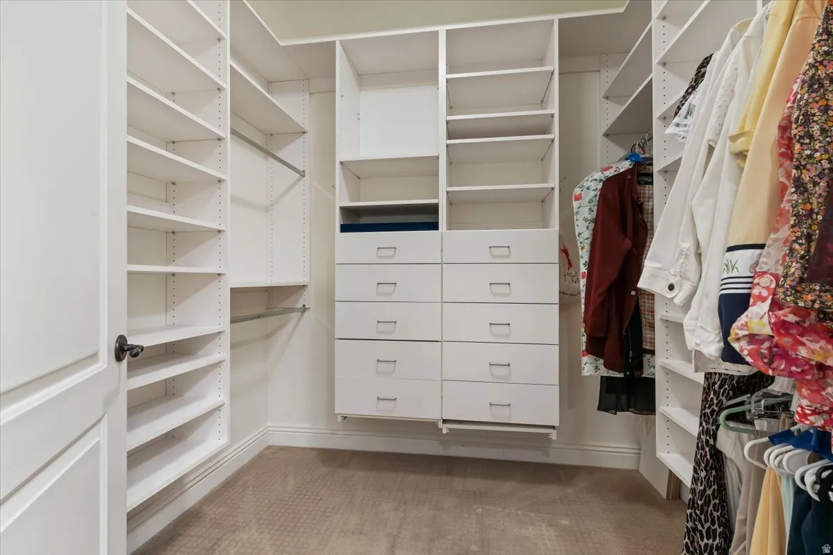 Walk in closet featuring light colored carpet
