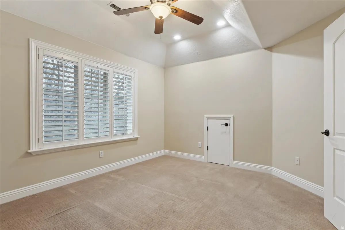 Empty room featuring ceiling fan, light carpet, and recessed lighting