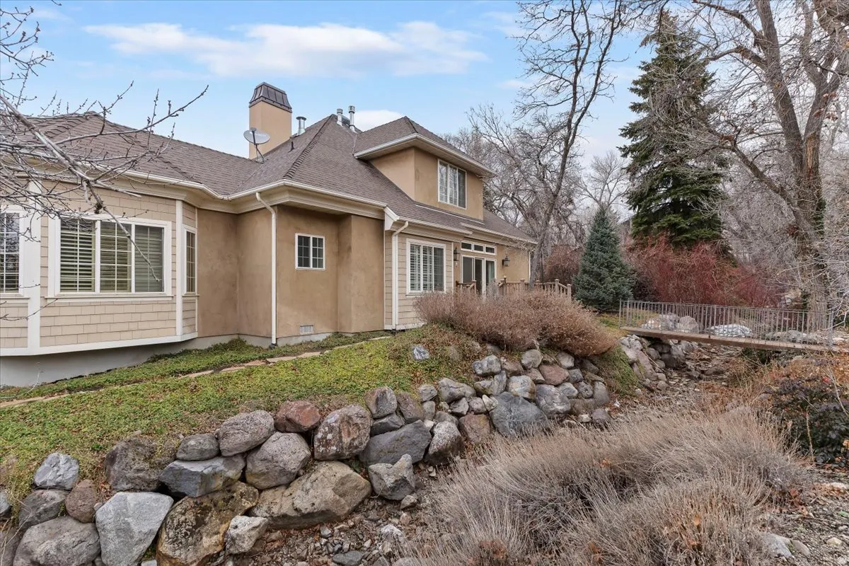 View of property exterior featuring roof with shingles, a chimney, and stucco siding