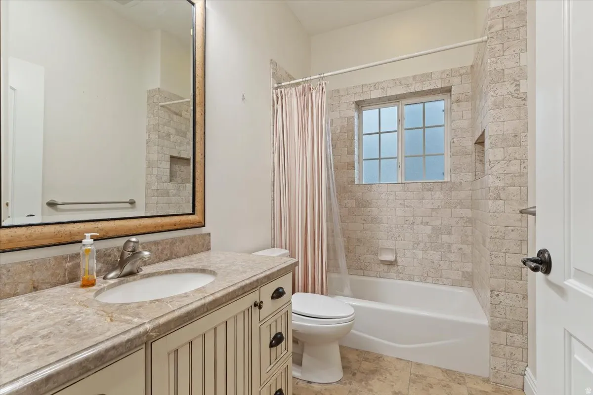 Bathroom with vanity and shower / bath combination with curtain