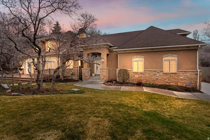 View of front of house with stucco siding and a lawn