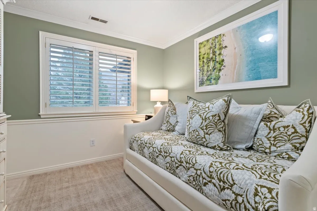 Bedroom featuring light carpet and ornamental molding