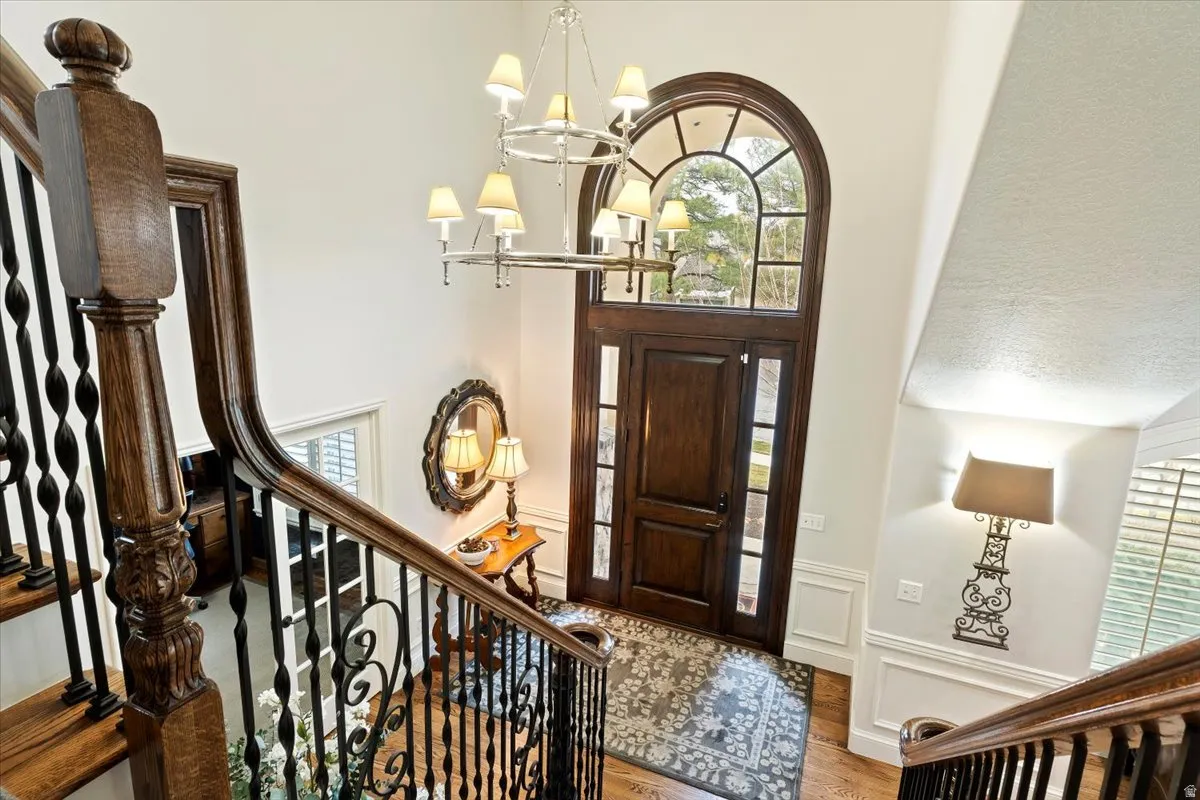 Foyer with suspended lighting, wood finished floors, and a decorative wall