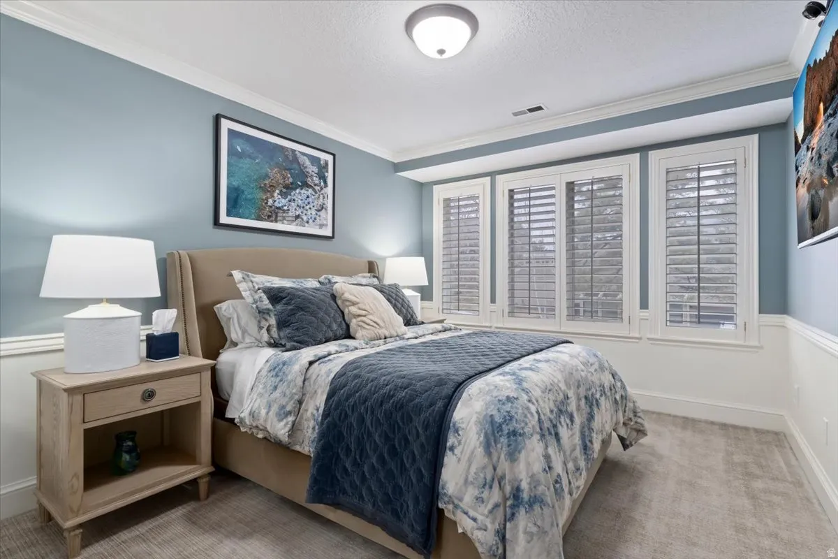 Bedroom featuring ornamental molding, carpet, and a textured ceiling