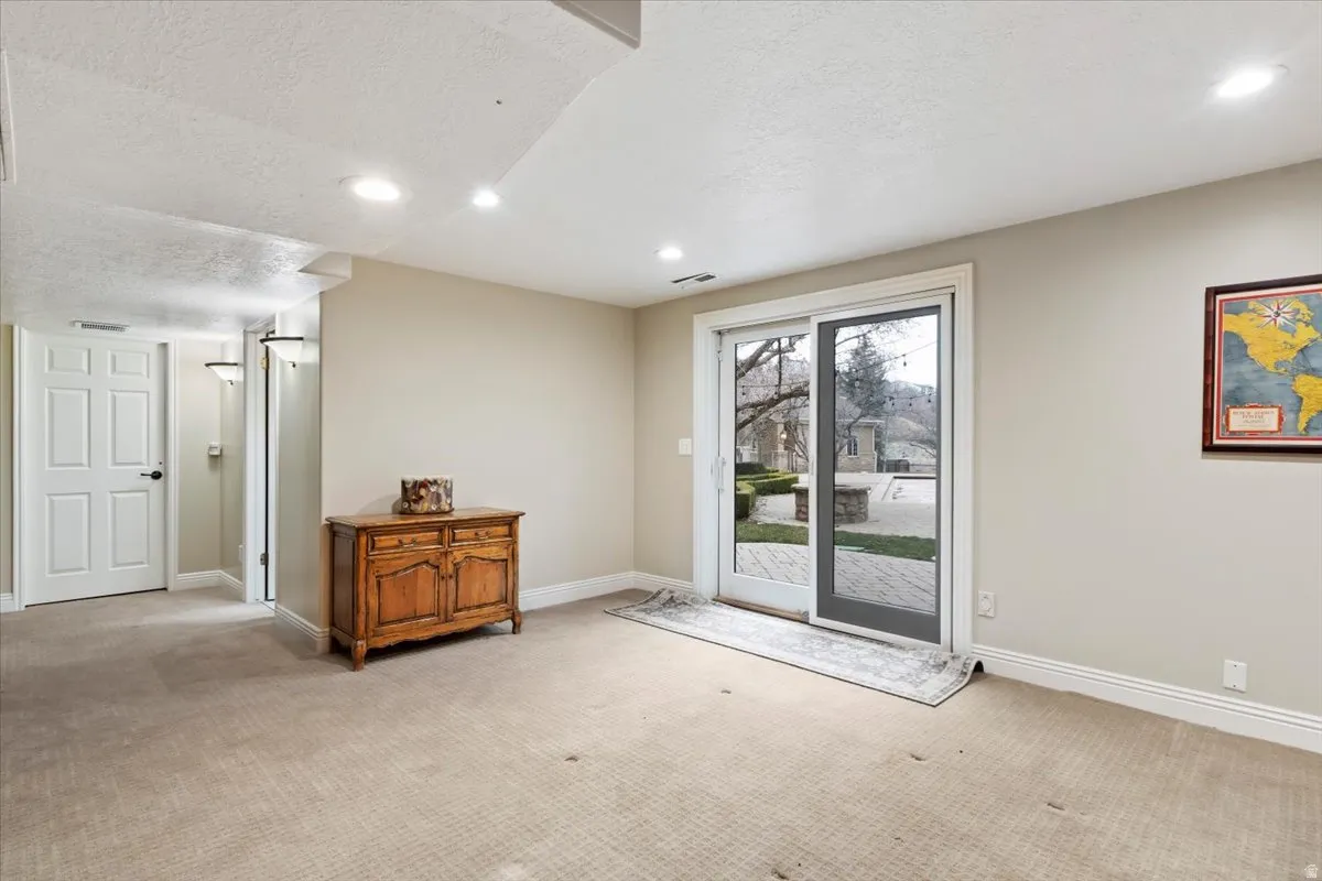 Entryway featuring a textured ceiling, carpet, and recessed lighting