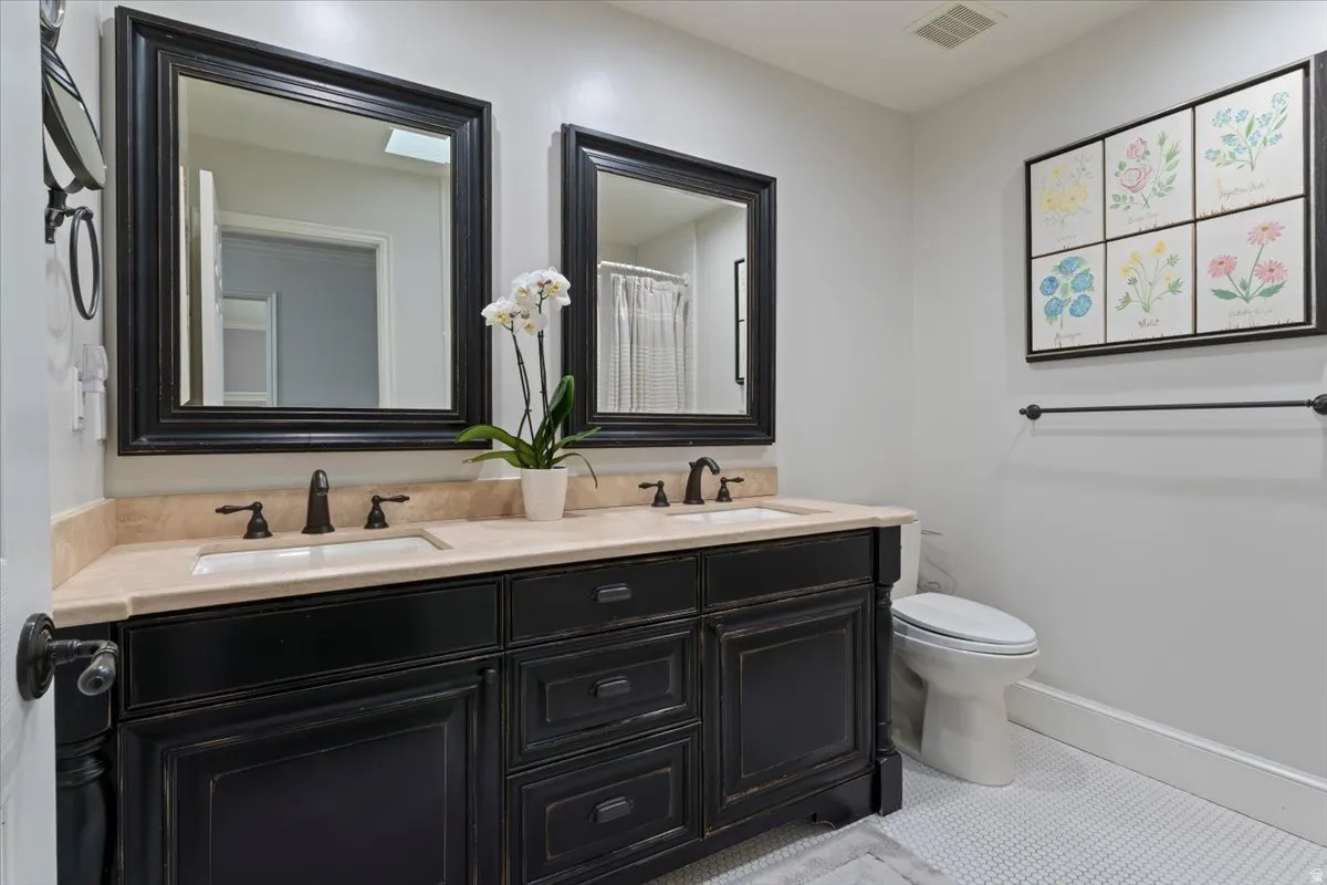 Full bath featuring double vanity and a shower with curtain