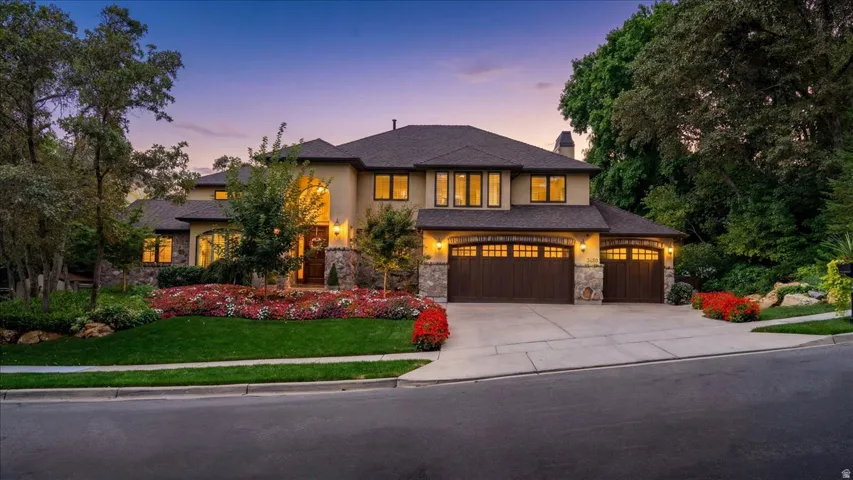 Prairie-style house with a front yard, a chimney, stone siding, driveway, and a garage