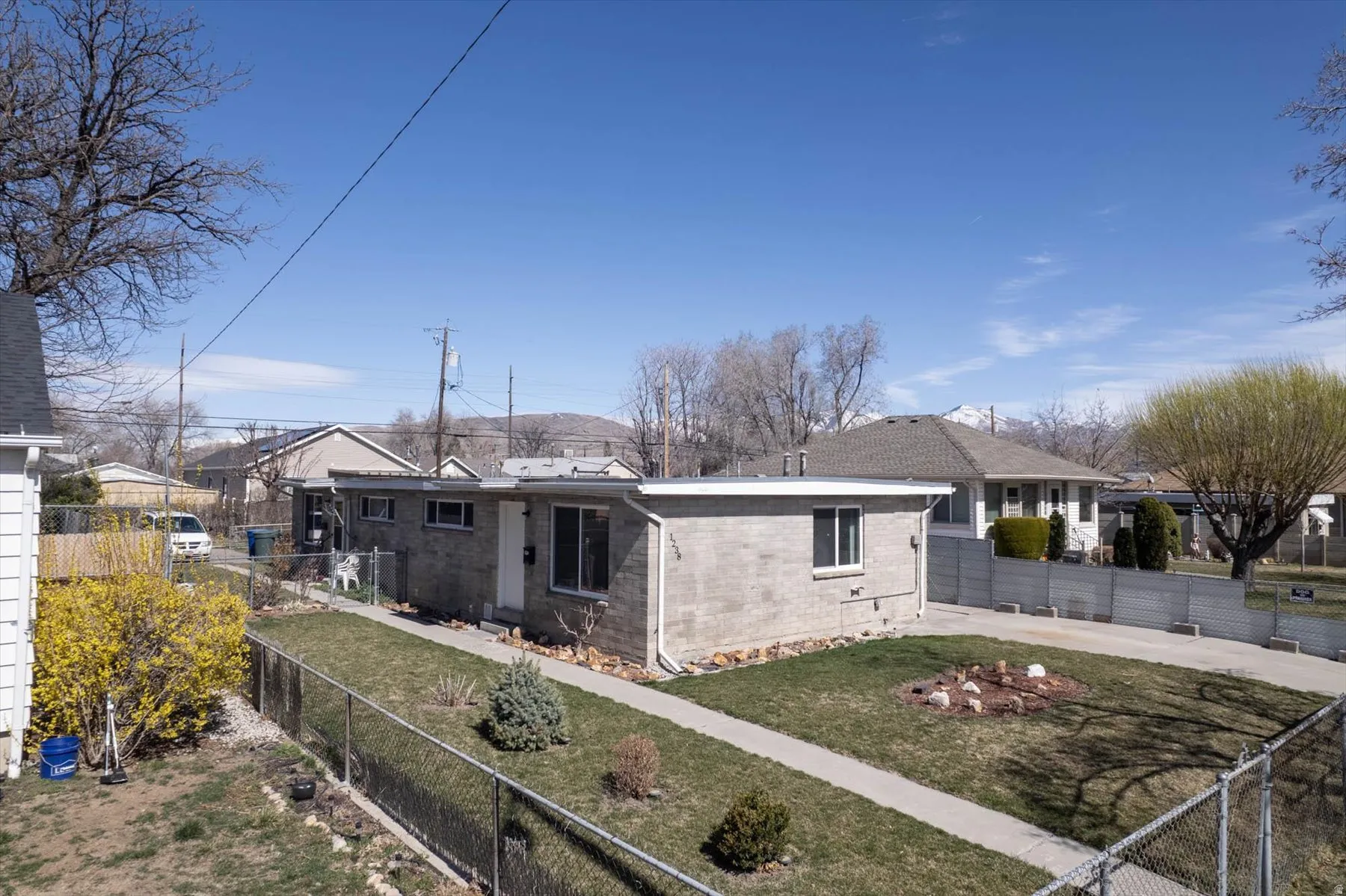View of front of home featuring a fenced front yard, brick siding, and a residential view