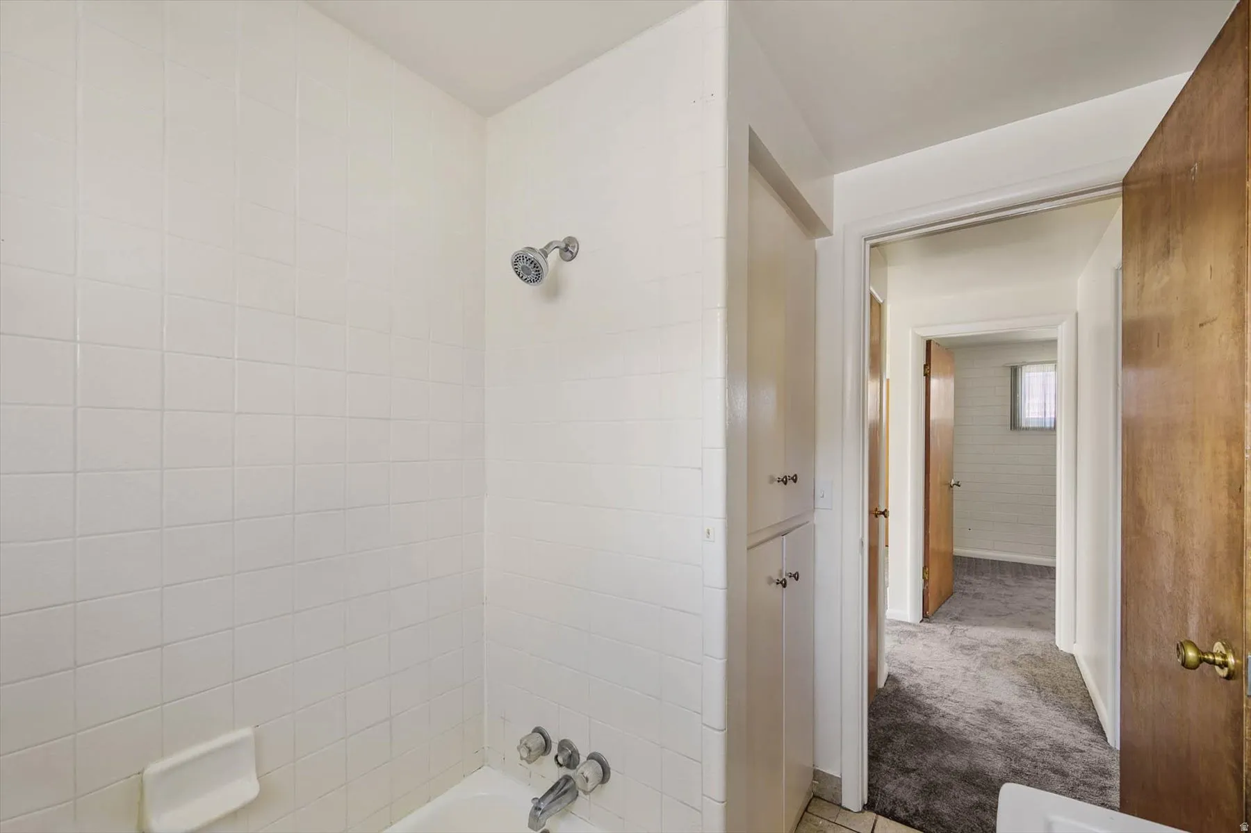 Full bath featuring washtub / shower combination and carpet floors