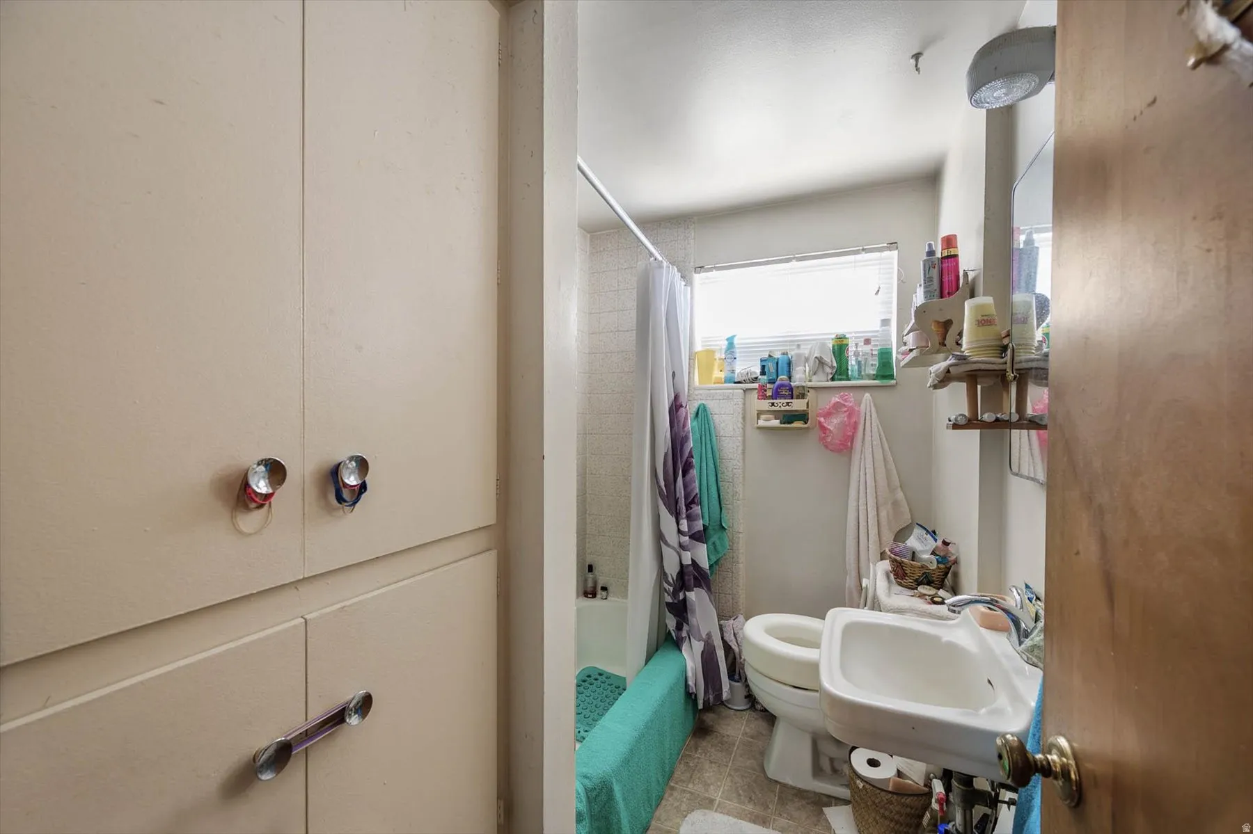 Full bath with shower / bathtub combination with curtain and light tile patterned flooring