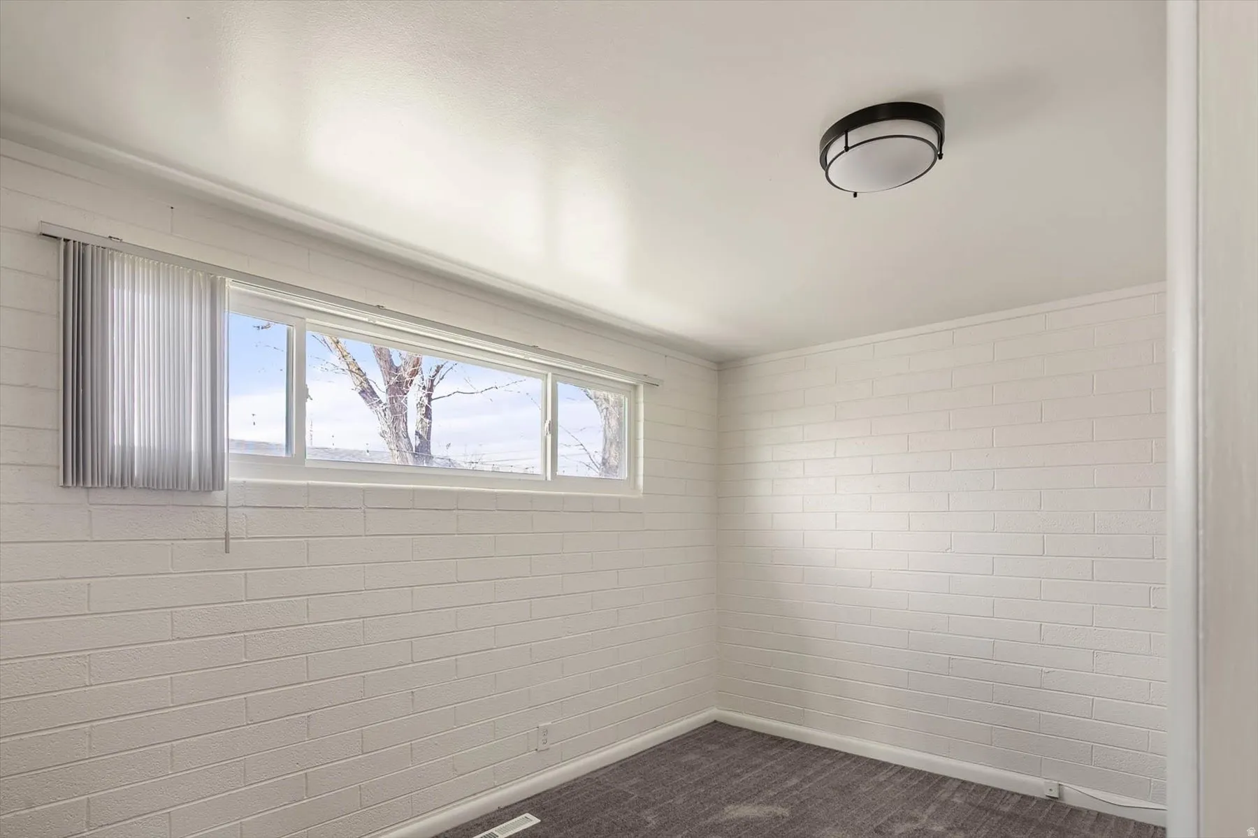 Spare room featuring dark colored carpet