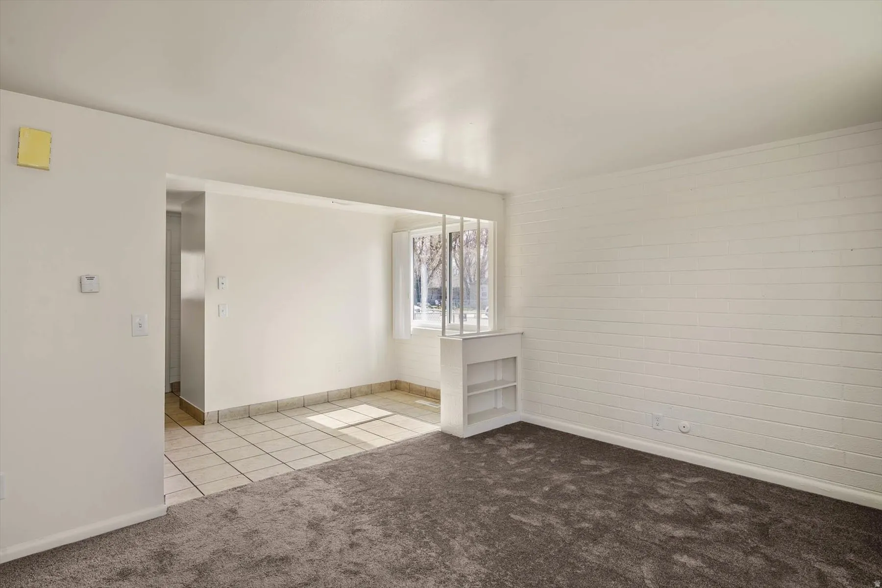 Empty room featuring carpet flooring and tile patterned flooring