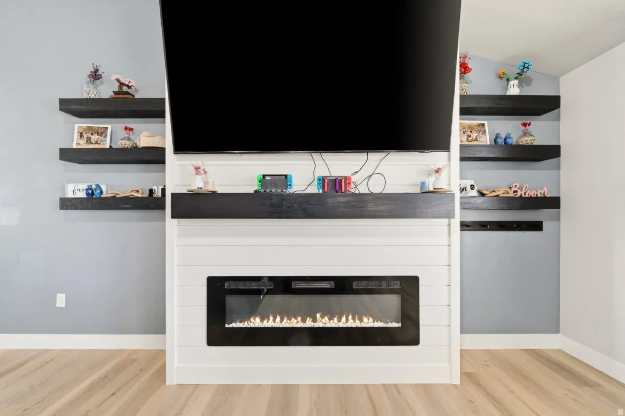 Detailed view of wood finished floors and a glass covered fireplace