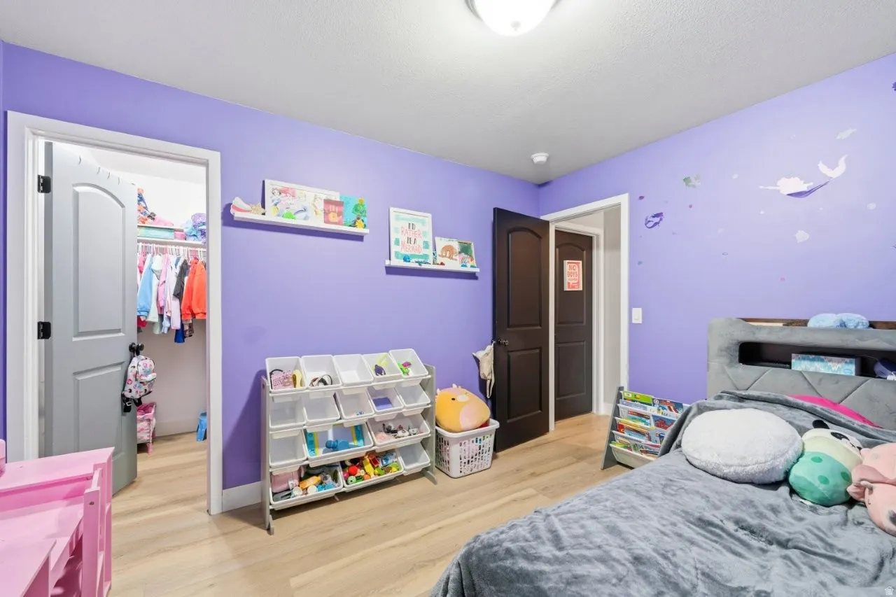 Bedroom with light wood-style floors and a spacious closet