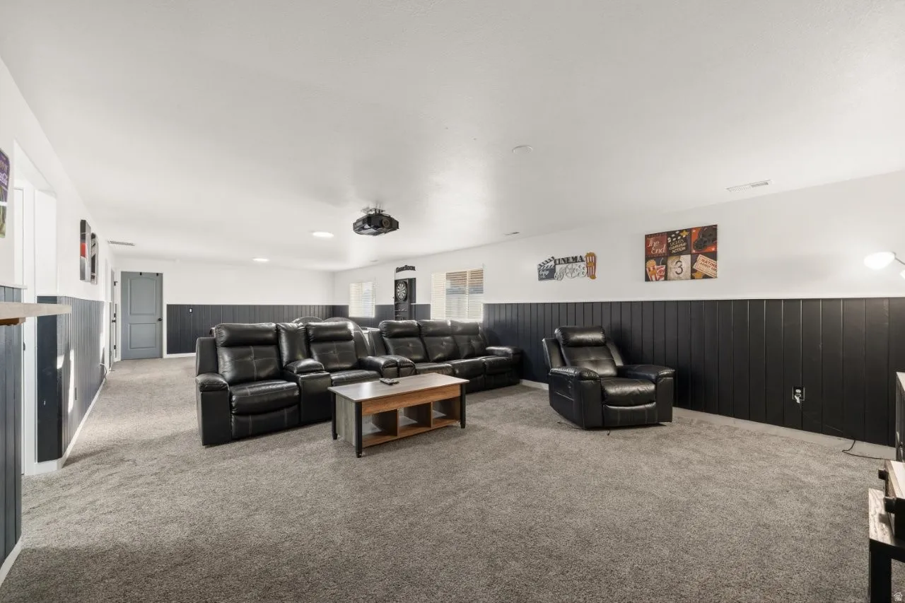 Cinema room with a wainscoted wall, carpet, and wood walls