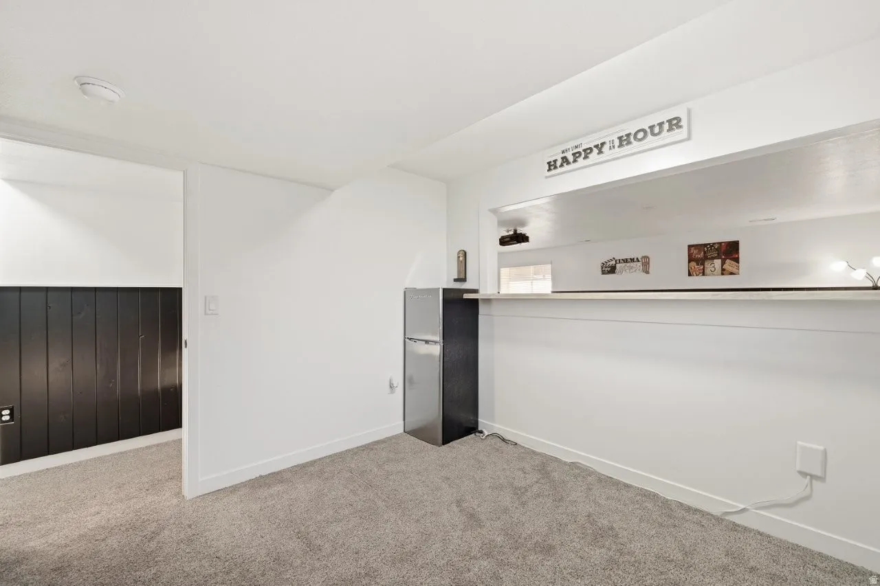 Carpeted spare room featuring wood walls and a wainscoted wall
