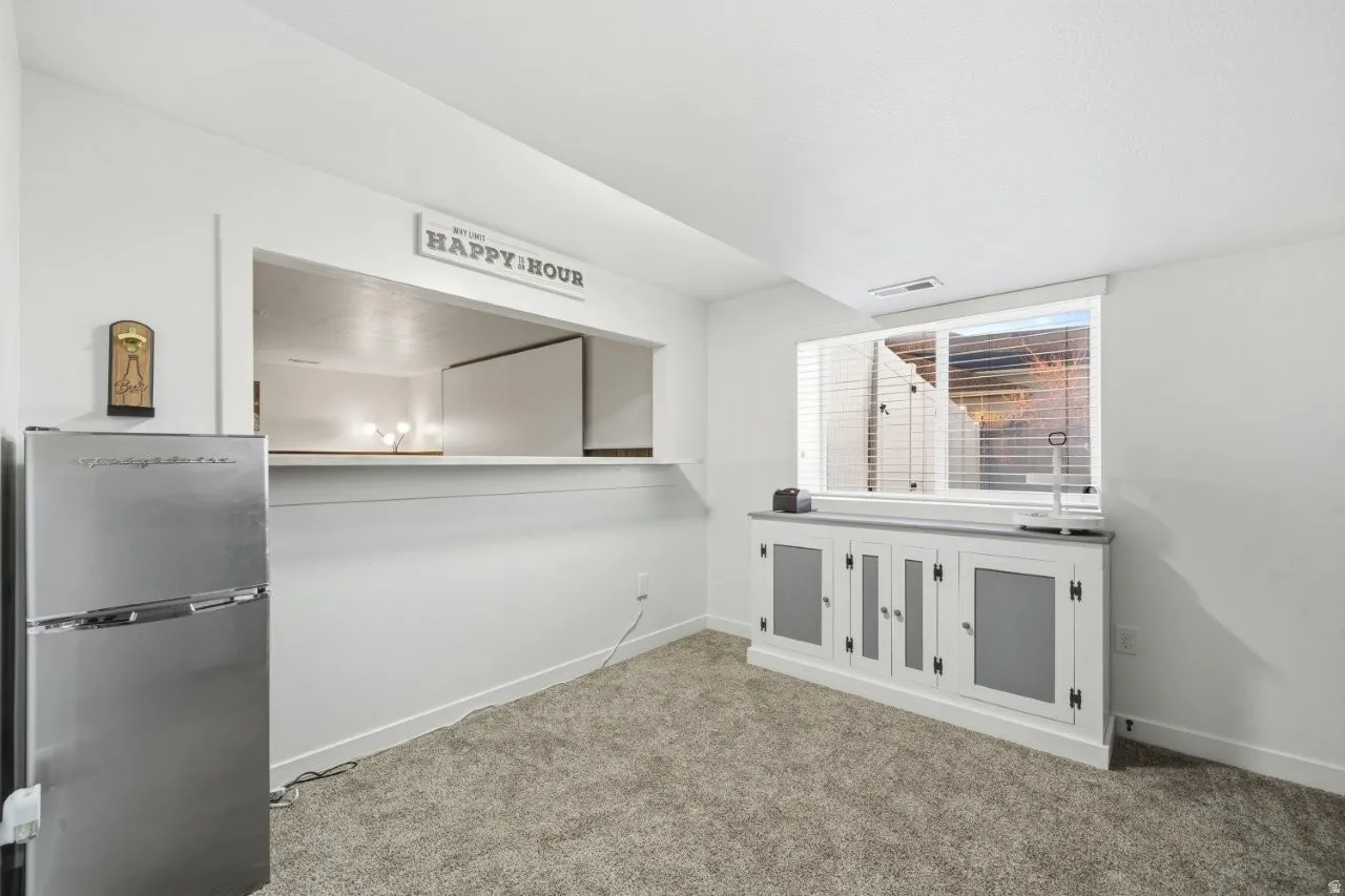 Interior space with freestanding refrigerator and carpet floors