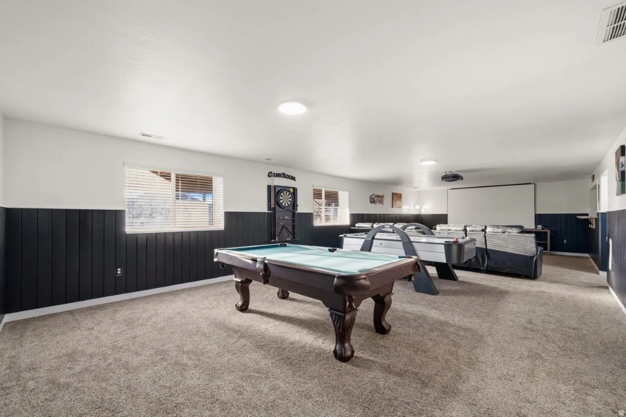 Game room featuring a wainscoted wall, wooden walls, carpet floors, and billiards table