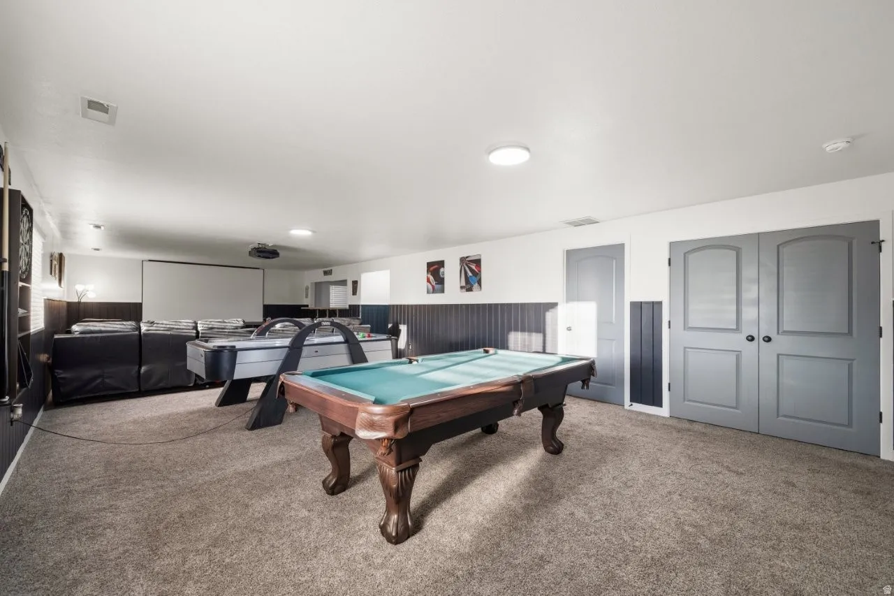 Game room featuring wainscoting, light carpet, pool table, and wood walls